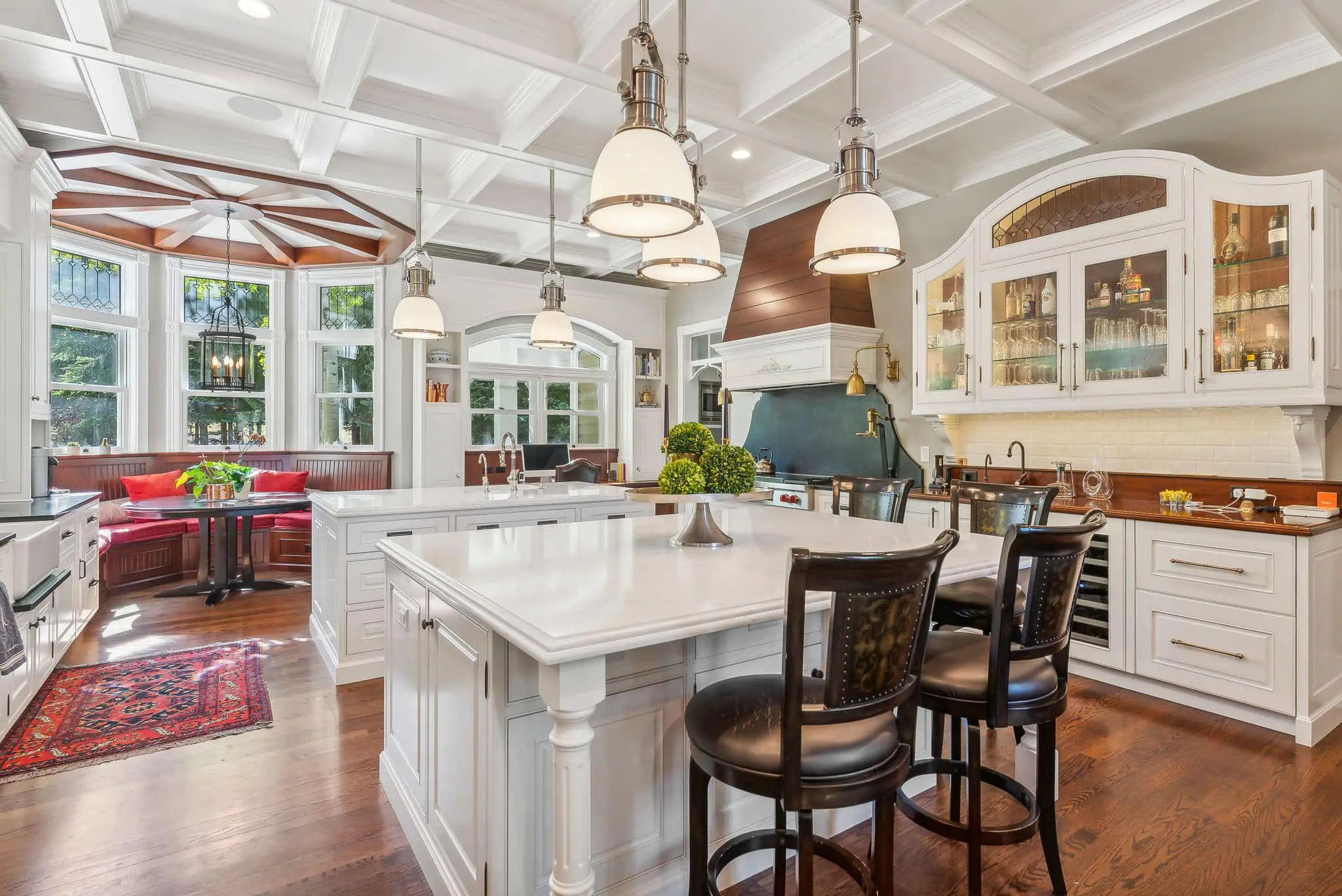 A kitchen with white cabinets and wooden floors