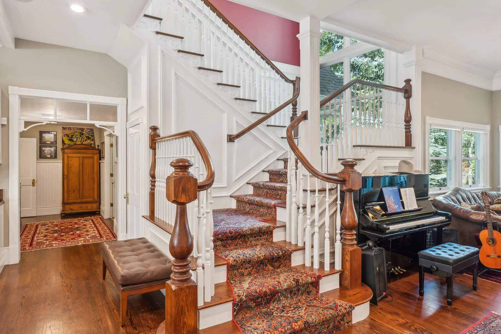 A living room with a piano and stairs