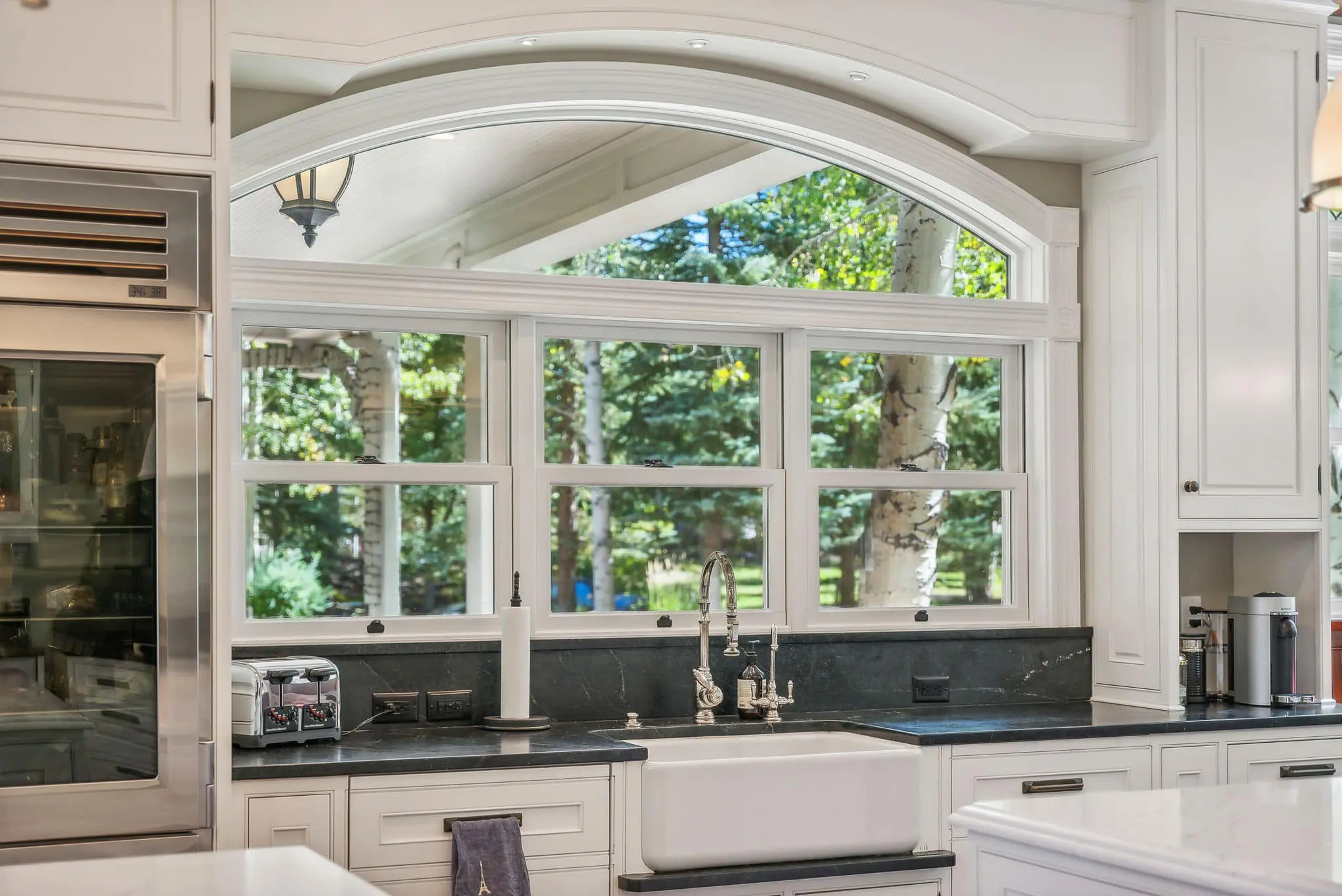 A kitchen with a sink and lots of windows.