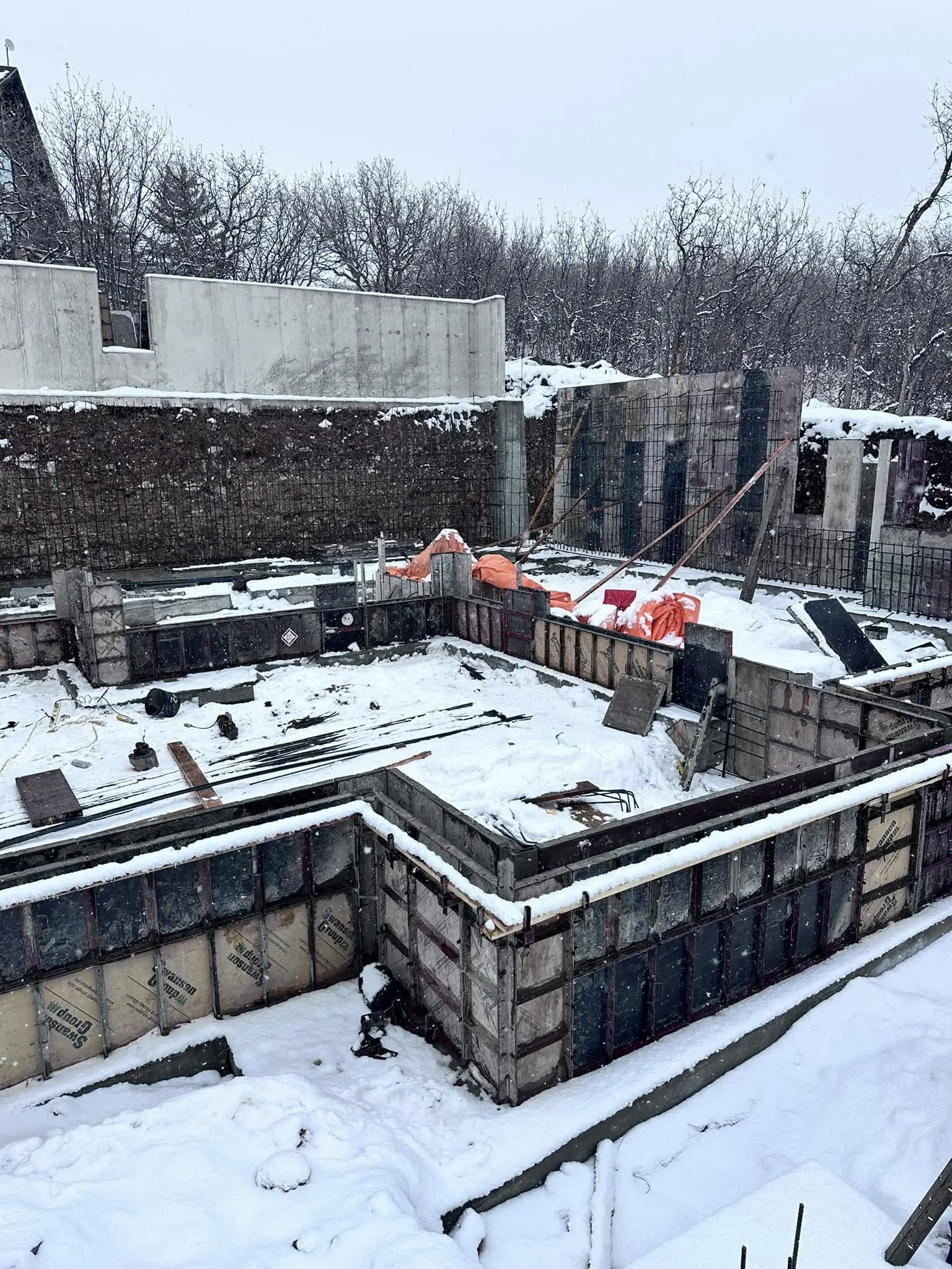 A building under construction with snow on the ground.