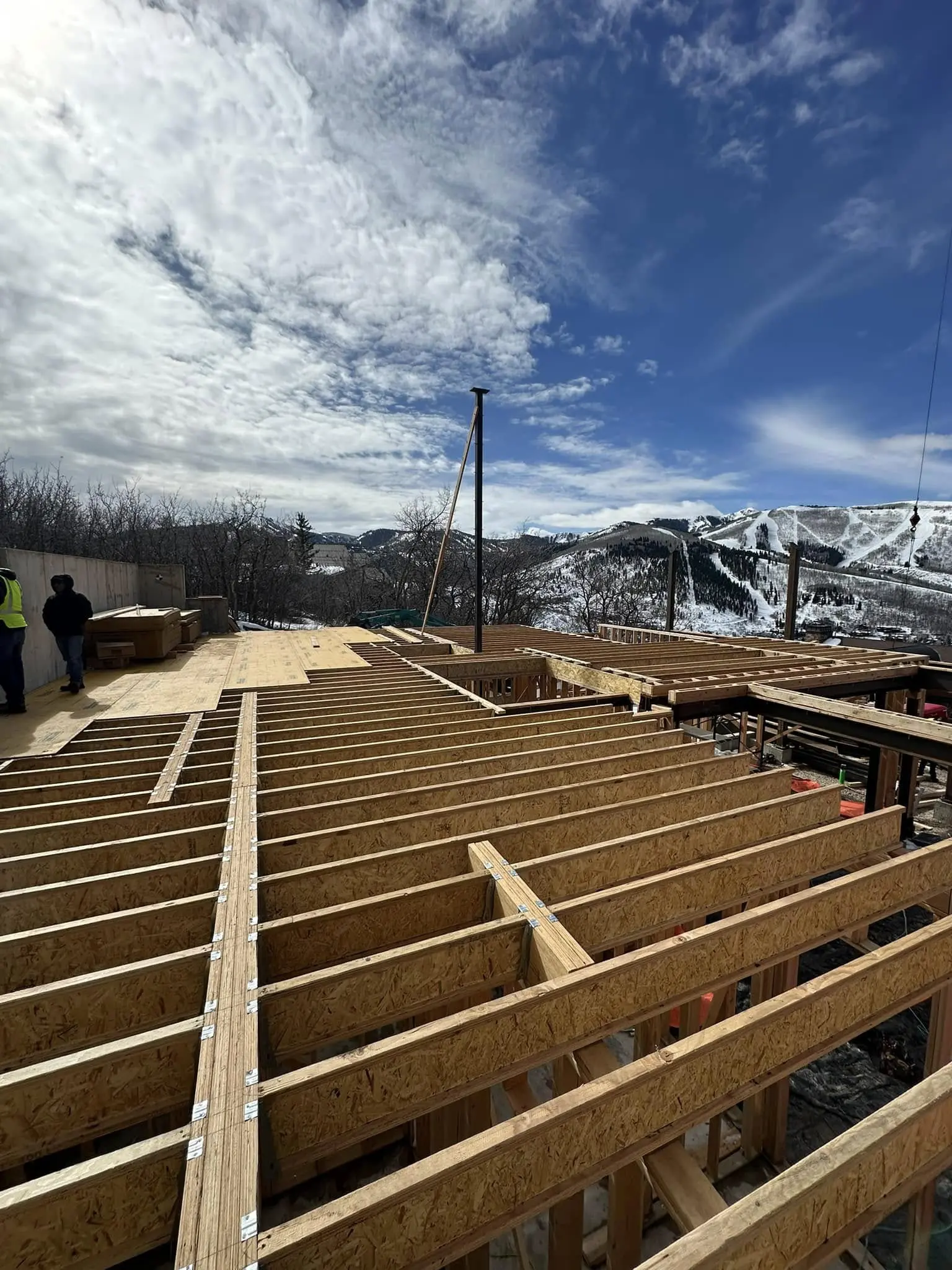 Construction site with wooden beams and mountains.